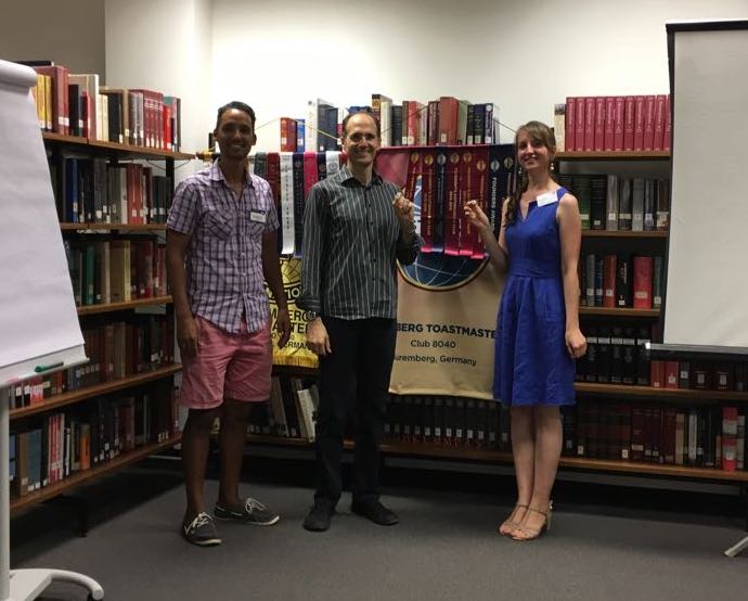 Club president, Hiram, presenting Susann and Norman with the icebreaker badges after the Nuremberg Toastmasters meeting